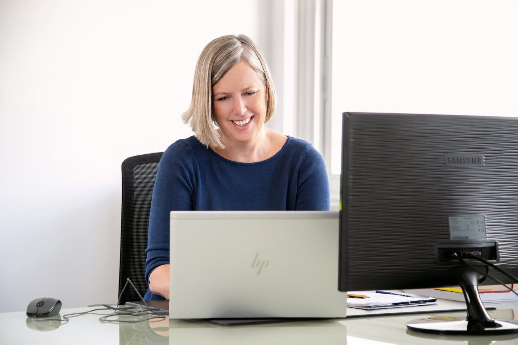 Jacqueline Widmer working at a computer and talking with someone online