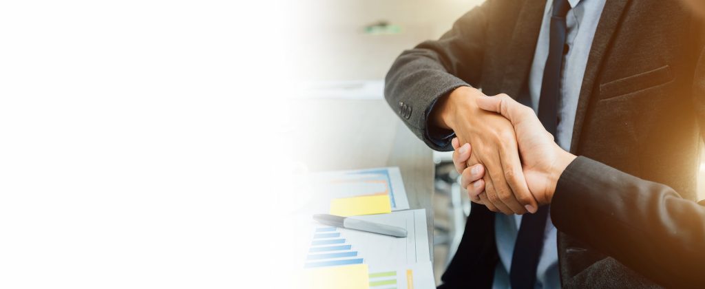 Two people in suits shaking hands