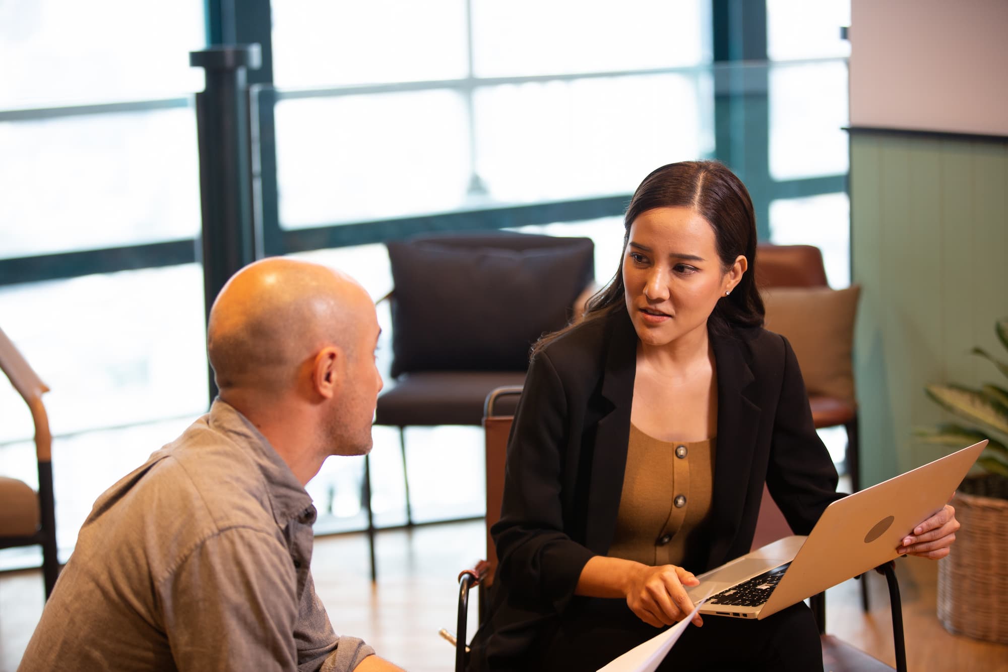 two people discussing business over a laptop