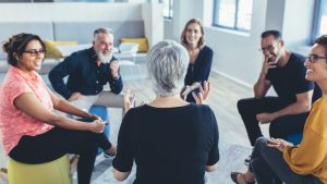 group of business professionals sitting in a circle and discussing